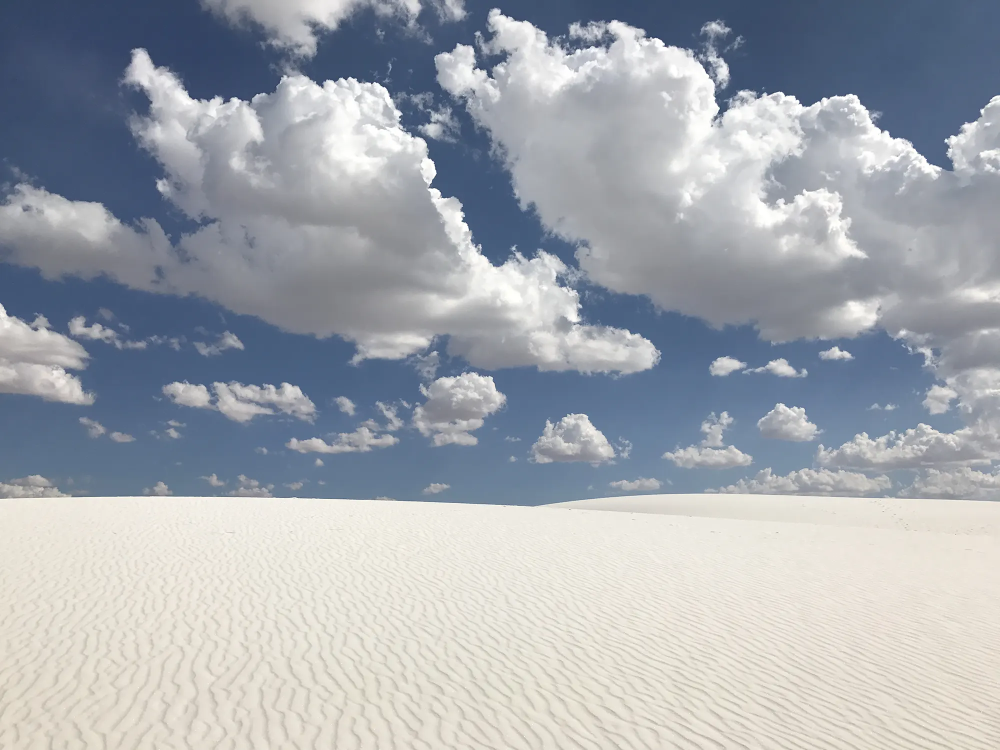 marketing communications infrastructure Flat white sand stretching to the horizon under large white clouds and blue sky